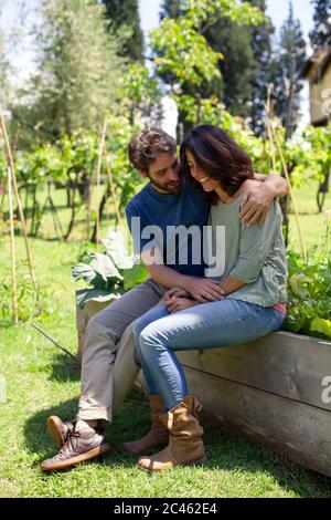 Affettuosa metà adulto giovane seduto in giardino Foto Stock