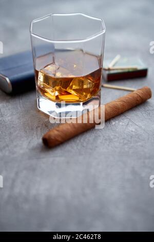 Bicchiere di whisky con ghiaccio, sigaro cubano grande, matches e matraccio d'anca Foto Stock