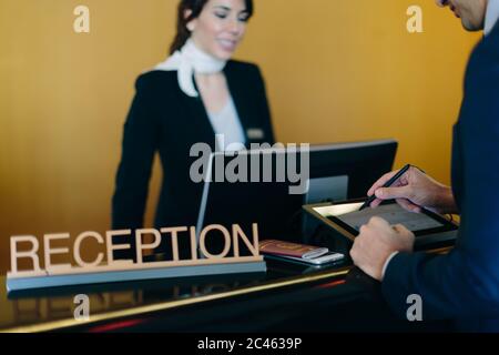 Imprenditore il check in presso la reception dell'hotel Foto Stock