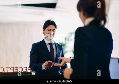 Imprenditore il check in presso la reception dell'hotel Foto Stock