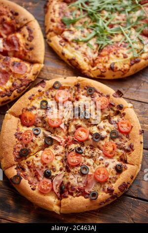 Composizione di tre diversi tipi di pizze sul tavolo di legno Foto Stock