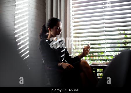 Sofisticato giovane donna bere champagne in boutique hotel ristorante, Italia Foto Stock