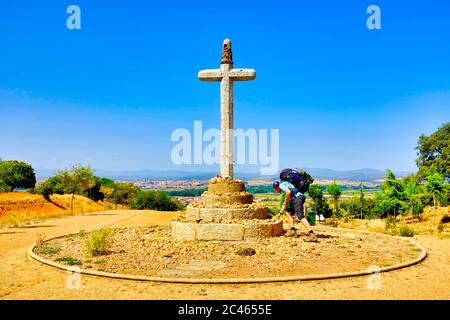 Pellegrino che posa una roccia sul Cruceiro de Santo Toribio a Justo de la Vega sulla strada di San Giacomo (Camino de Santiago), Castiglia e León, Spagna Foto Stock