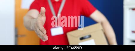 Corriere maschile in uniforme che tiene un primo piano di un pacco Foto Stock