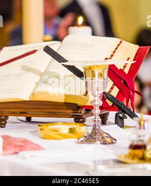 altare con ostia che diventa corpo di gesù cristo e calice per il vino, sangue di cristo, con il libro per la messa dei fedeli Foto Stock