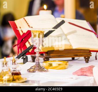 altare con ostia che diventa corpo di gesù cristo e calice per il vino, sangue di cristo, con il libro per la messa dei fedeli Foto Stock