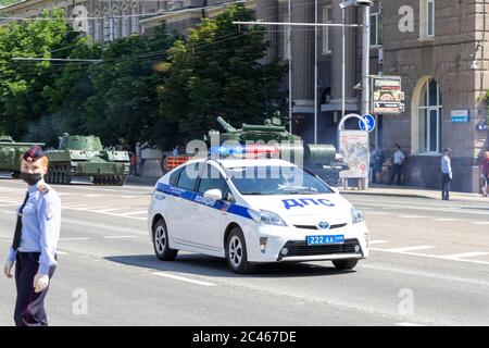 Donetsk, Donetsk Repubblica popolare Ucraina - 24 giugno 2020: Un'auto di polizia accompagna il movimento di attrezzature militari alla Parata della Vittoria. Foto Stock