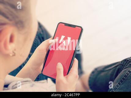 KIEV, UCRAINA-GENNAIO, 2020: Adobe sullo schermo del telefono cellulare. Young Girl che punta o guarda su Adobe Site durante un Pandemic Self-Isolation e la prevenzione del Coronavirus. Foto Stock