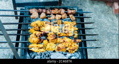 Spiedini misti alla griglia di carne di pollo e agnello marinati arrostire sulla griglia di barbecue cucinati per. Barbecue Foto Stock