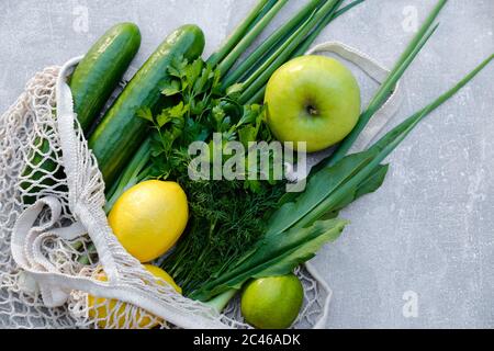 Borsa riutilizzabile in cotone con verdure fresche su fondo di pietra. Concetto sano di acquisto di cibo biologico. Foto Stock