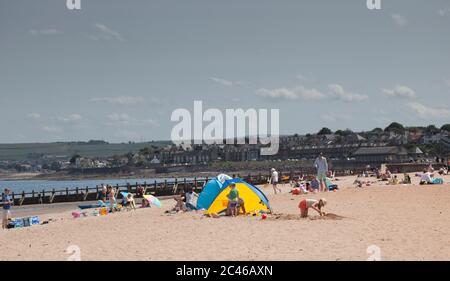 Portobello, Edimburgo, Scozia, Regno Unito. 24 giugno 2020. Il caldo tempo ha portato le famiglie fuori ma il mare non era troppo occupato, molto spazio per mantenere una distanza sociale sulla spiaggia e sul lungomare. Persone su varie tavole da paddle e gonfiabili. Foto Stock