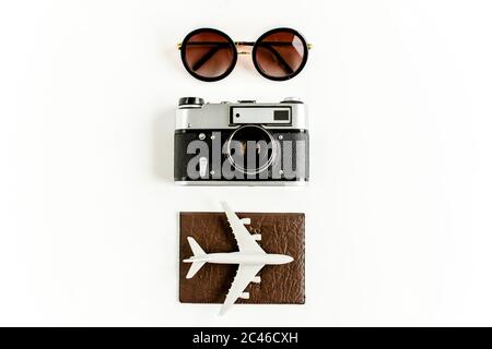 Concetto di accessori per viaggiatori su sfondo bianco. Telecamera retrò, telefono, occhiali da sole. Sfondo estivo. Disposizione piatta Foto Stock