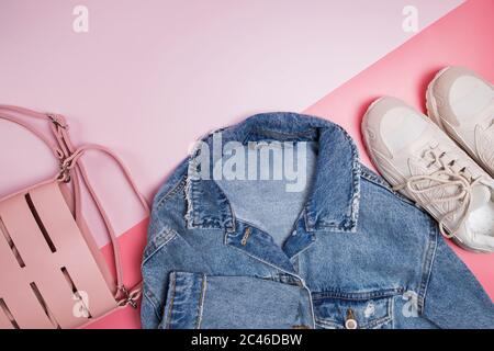 Giacca, borsa e sneaker in denim su sfondo rosa Foto Stock