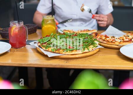 Pizza intera e limonata fresca su un tavolo da terrazza in Italia Foto Stock