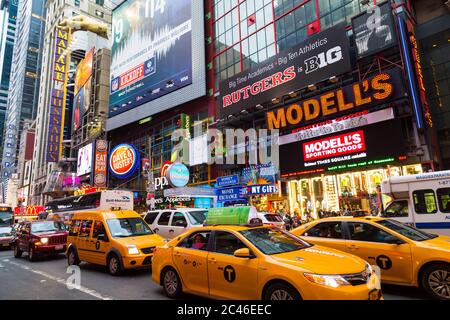 NEW YORK CITY, USA - 30 AGOSTO 2014: L'esterno degli edifici lungo la 42nd Street a New York City mostrando un sacco di pubblicità e taxi gialli Foto Stock