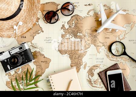 Pianificazione vacanza, piano di viaggio, vacanza viaggio utilizzando mappa del mondo insieme ad altri accessori di viaggio. Vista dall'alto, disposizione piatta. Foto Stock