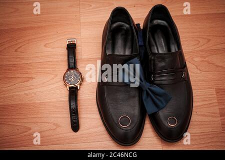 Scarpe e orologio da polso sono appoggiati sul tavolo Foto Stock