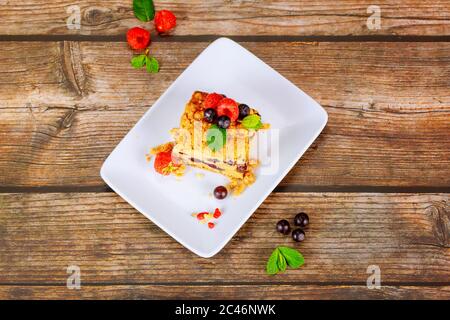 Pezzo di torta di caffè di mirtillo fatta in casa con frutti di bosco freschi su piastra bianca su sfondo di legno. Foto Stock