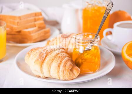 Cornetti freschi panini, arance, marmellata d'arancia colazione concetto Foto Stock