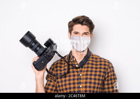 Primo piano ritratto del suo bel ragazzo sano che tiene in mano fotocamera indossare maschera di sicurezza mers COV infezione influenza Grifpe misure preventive Foto Stock