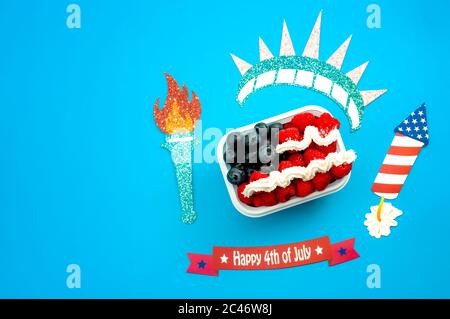 Giornata dell'indipendenza, felice quarto di luglio e dessert concetto con la bandiera americana fatta di lamponi e mirtilli circondati da decorazioni, isola Foto Stock
