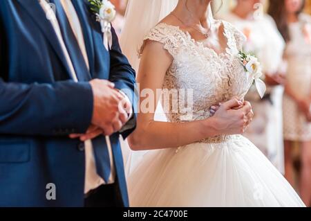 Sposa e sposo pregano nella chiesa Foto Stock