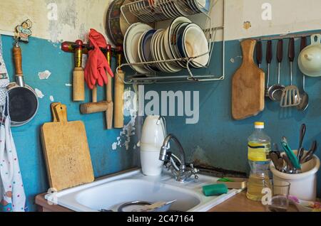 Vista del lavabo sporco della cucina con piatti di persone solitarie anziane Foto Stock
