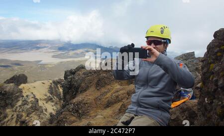 Parque Nacional Cotopaxi, Cotopaxi / Ecuador - 2 agosto 2017: Scalatore maschile che scatta foto del paesaggio dalla cima del vulcano Ruminahui all'interno Foto Stock