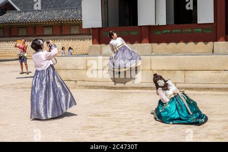 Una donna coreana locale di fronte al palazzo reale di Seoul che indossa un Hanok, un abito tradizionale coreano. Foto Stock