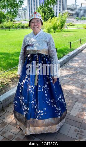 Una donna coreana locale di fronte al palazzo reale di Seoul che indossa un Hanok, un abito tradizionale coreano. Foto Stock