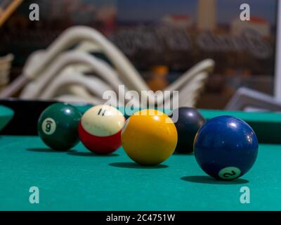 Palline da biliardo sul tavolo sotto le luci con un sfondo sfocato - concetto di intrattenimento Foto Stock