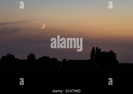 Piccola luna falciforme nel cielo crepuscolo Foto Stock