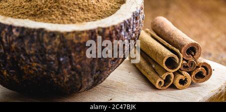 cannella in un recipiente rustico, fatto di conchiglia di cocco, cannella macinata utilizzata nella cucina mondiale. Foto Stock