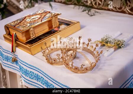 Corone d'oro della Bibbia e coppia di candele sul tavolo Foto Stock