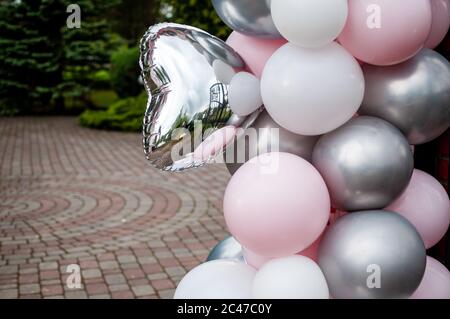 Palloncini gonfiabili in grigio rosa e bianco nel cortile Foto Stock