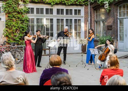 Berlino, Germania. 23 Giugno 2020. Si guarda un concerto di cortile eseguito da membri dell'orchestra Staatskapelle Berlin a Berlino, capitale della Germania, il 23 giugno 2020. Credit: Peter Adamik/Xinhua/Alamy Live News Foto Stock