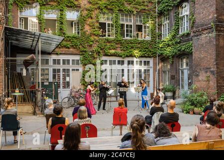 Berlino, Germania. 23 Giugno 2020. Si guarda un concerto di cortile eseguito da membri dell'orchestra Staatskapelle Berlin a Berlino, capitale della Germania, il 23 giugno 2020. Credit: Peter Adamik/Xinhua/Alamy Live News Foto Stock