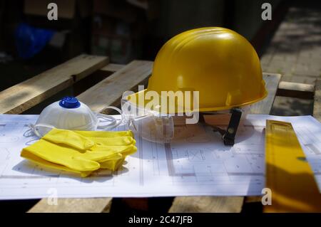 Casco, occhiali, maschera e guanti. Dispositivi di protezione individuale sul cantiere. Industria pesante. Foto Stock