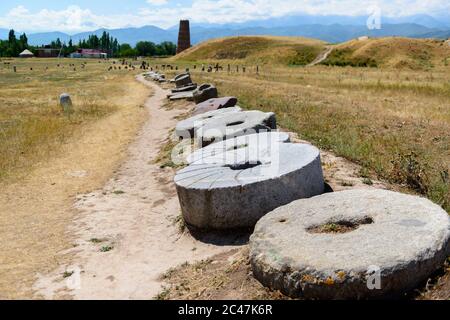 Segni di tomba e pietre del mulino nel sito archeologico della torre Burana. Kirghizistan Foto Stock