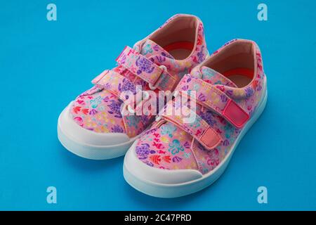 Scarpe casual colorate per bambini isolate su sfondo blu Foto Stock