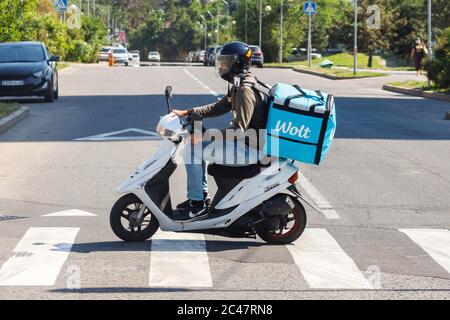 Almaty, Kazakhstan - 13 giugno 2020: Il corriere Wolt con scooter a motore sulla strada di Almaty Foto Stock