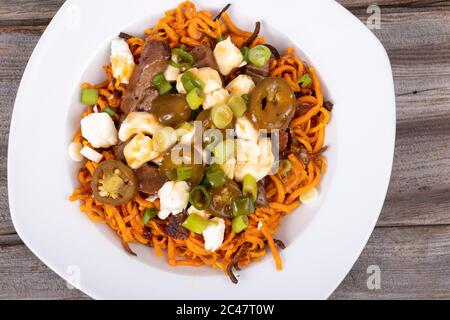 jalapeno di patate dolci e poutine di manzo piatto canadese condito con oignon verde Foto Stock