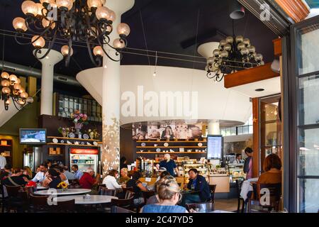 Le persone si siedono all'interno di un moderno, trendy cafe gourmet e panetteria per un servizio informale con diversi clienti nel centro di Santa Barbara, CA, USA Foto Stock