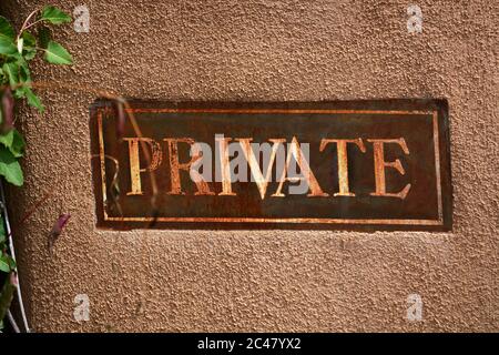 Un cartello 'privato' incorporato in un muro di adobe di fronte a una casa a Santa Fe, New Mexico. Foto Stock