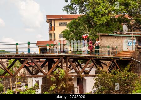 Donne che attraversano il vecchio ponte ferroviario Freetown, il ponte Tengbeh, trasportando merci in testa Foto Stock