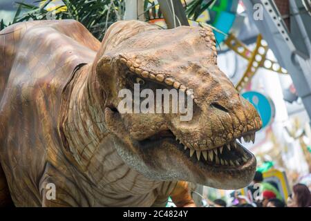 Il T-Rex dal parco Jurassic cerca di spaventare i turisti in una sfilata di studi universali. Un parco a tema situato all'interno del Resorts World Sentosa Singapore. Foto Stock