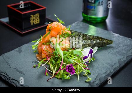 Sushi. Cucina tradizionale giapponese, salmone di alta qualità Temaki decorato in un ambiente elegante. Foto Stock