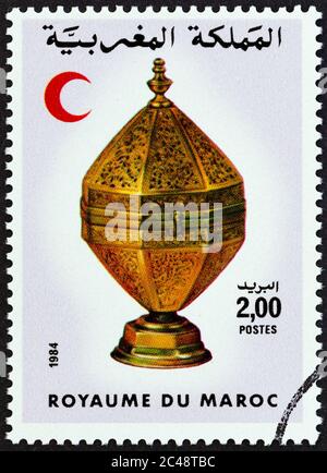 MAROCCO - CIRCA 1984: Un francobollo stampato in Marocco mostra la Crescent Rossa e ottagonale contenitore in ottone, circa 1984. Foto Stock