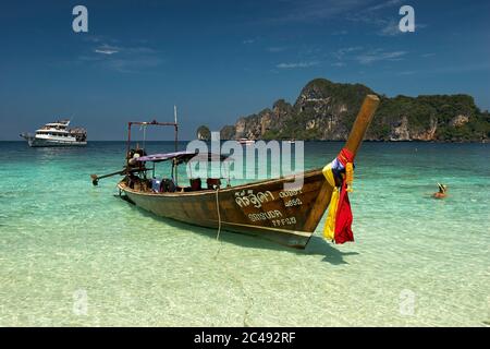 Tradizionale barca tailandese a coda lunga ormeggiata presso la spiaggia delle scimmie sull'isola di Phi Phi Don. Arcipelago di Ko Phi Phi, Thailandia. Foto Stock