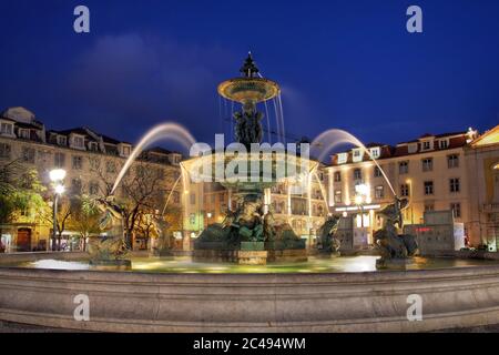 Notte Illuminata fontana nella piazza Rossio, Lisbona, Portogallo Foto Stock